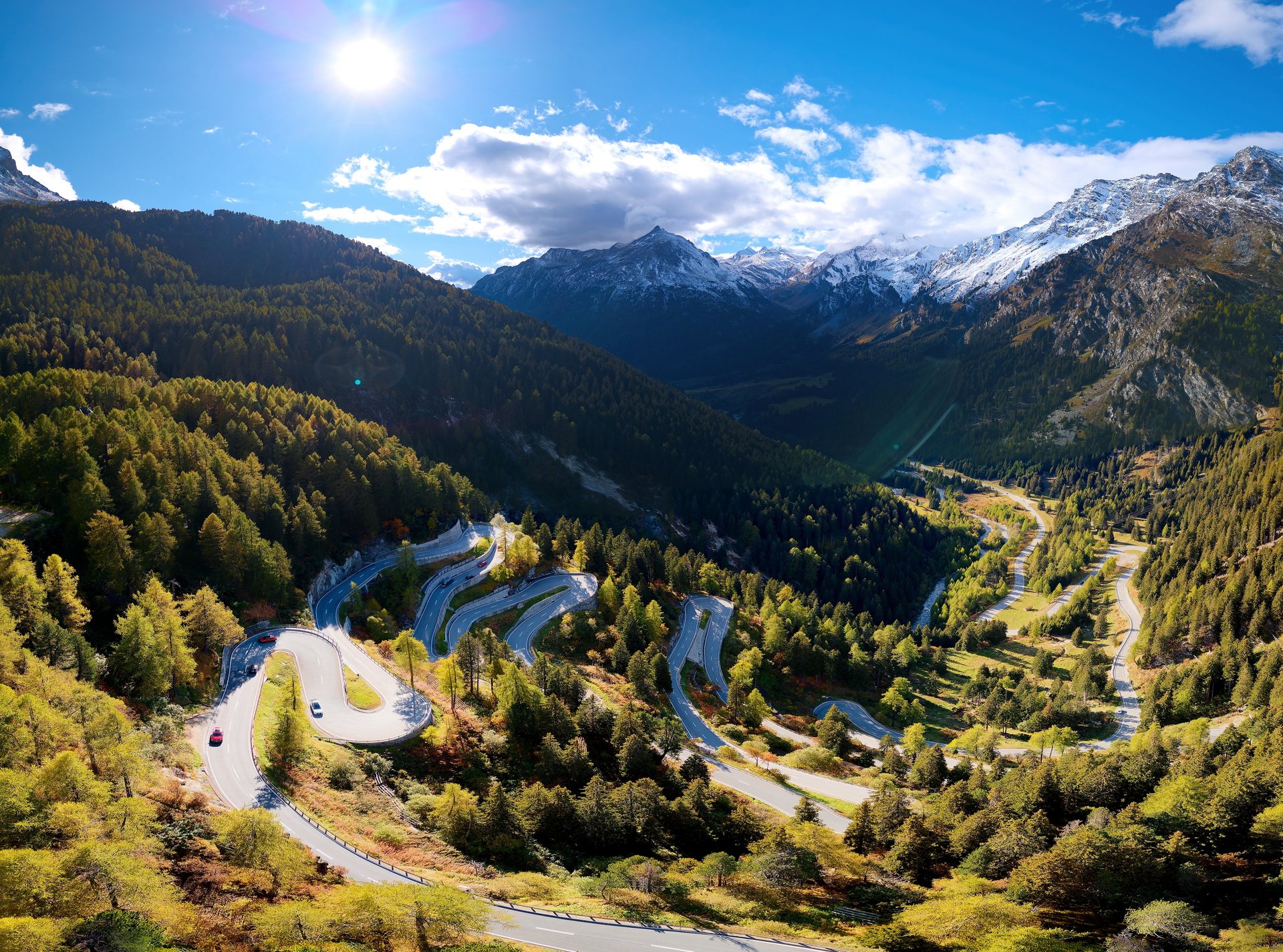 Alpine hairpin road winding through a mountain valley